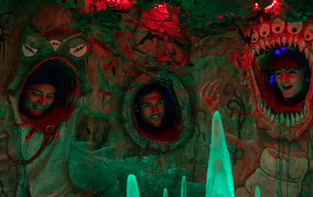 Family laughing together while interacting with a face in sculpture